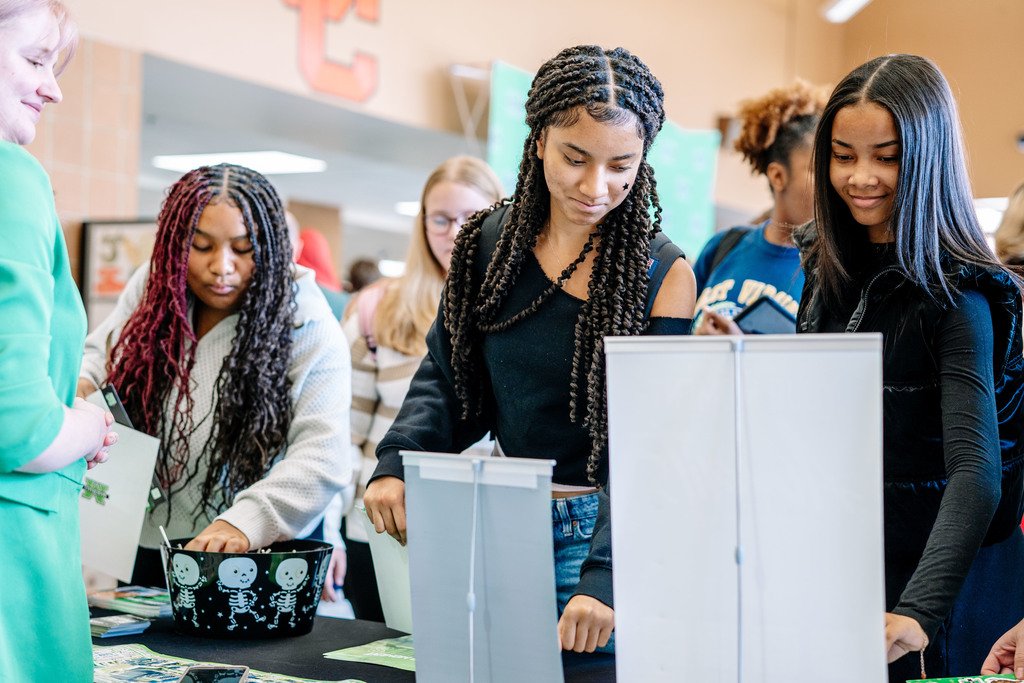 three south charleston students speaking with a Marshall recruiter after the program.