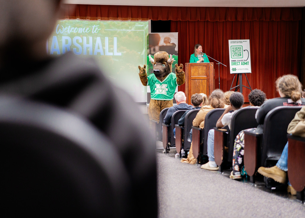 Marshall University mascot, Marco, giving the horns up sign to students at the end of the event.