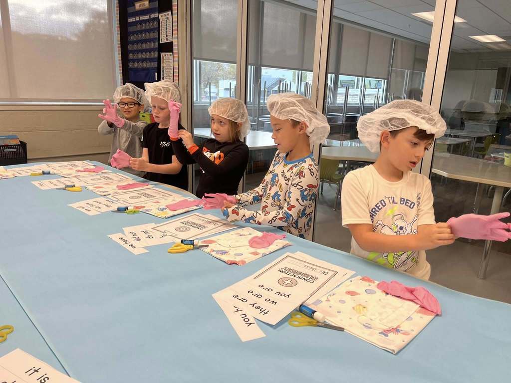 five students getting their surgical gear on for their contraction surgery lesson.