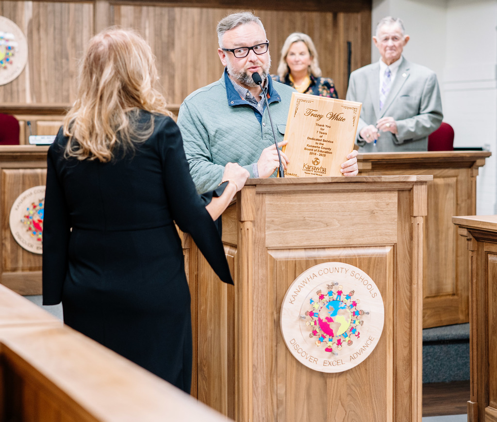 kcsboe president ric cavendar presenting former board member tracy white with a plaque during the board meeting.