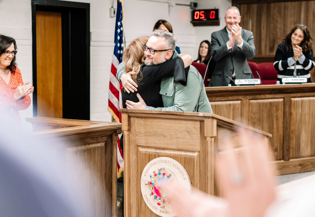 kcsboe president ric cavendar giving former board memeber tracy white a hug.