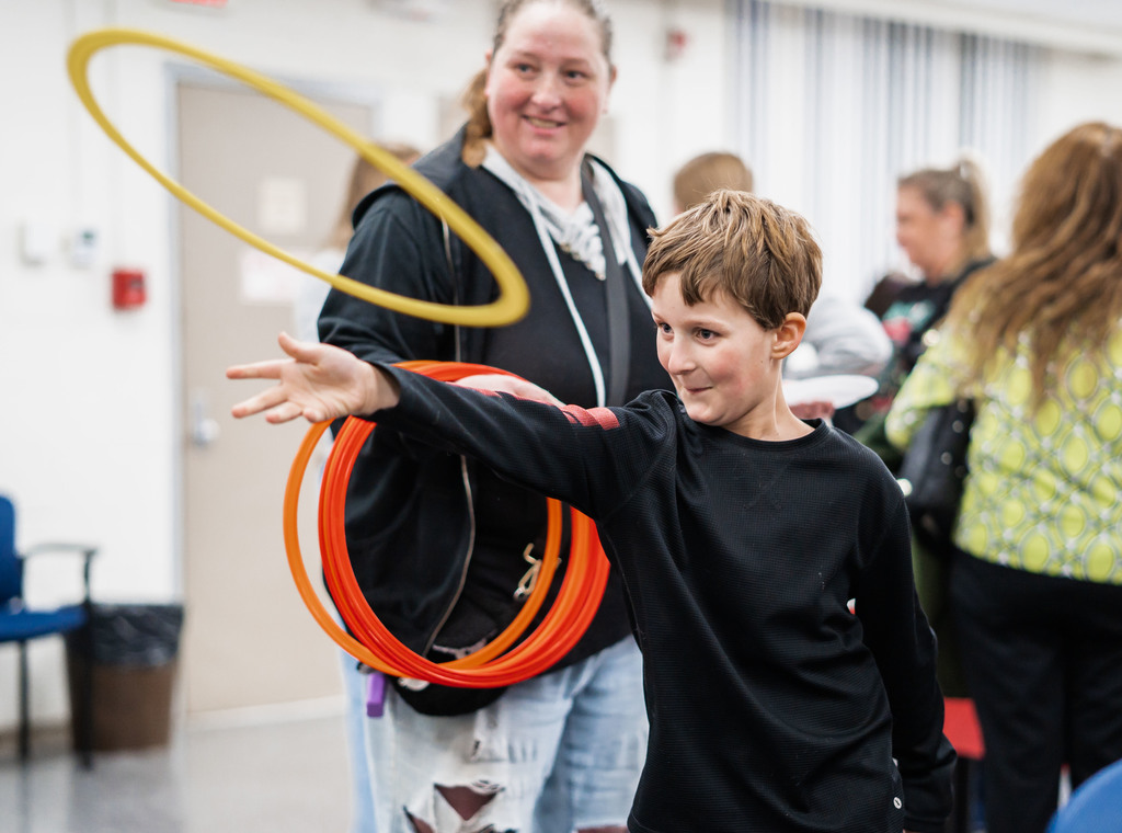 a student throwing a large ring while playing a ring toss game.