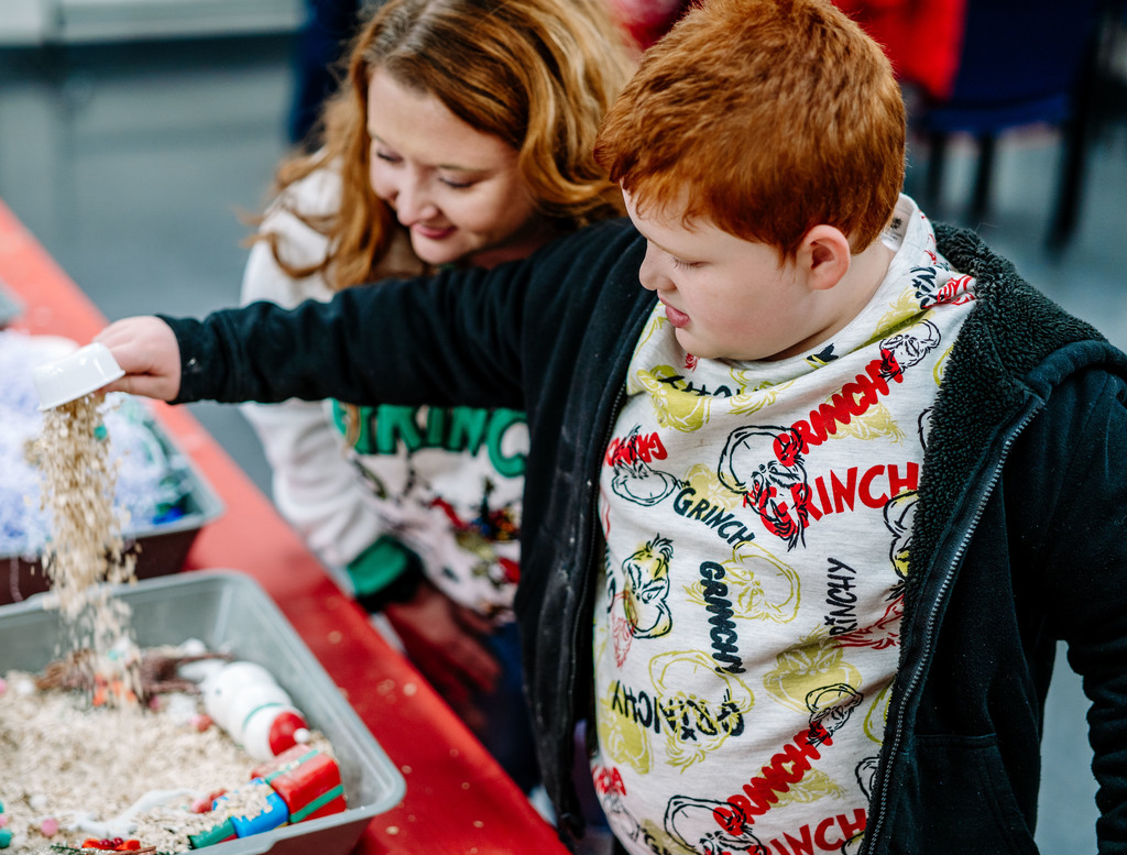 a student and his mom playing in sensory bins. 