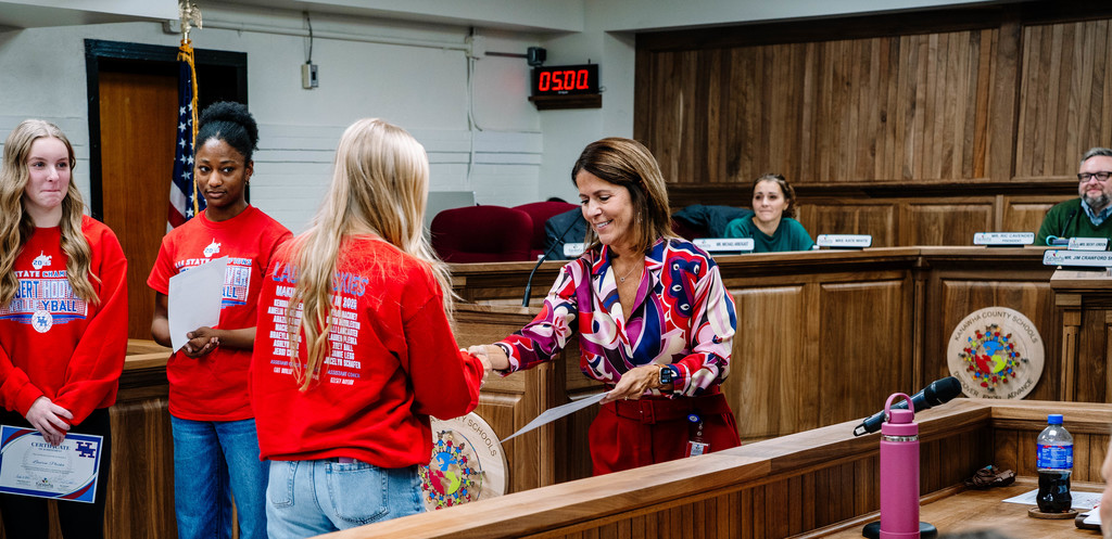 HHHS volleyball player walking up to get her certificate at the kcs board of education meeting.