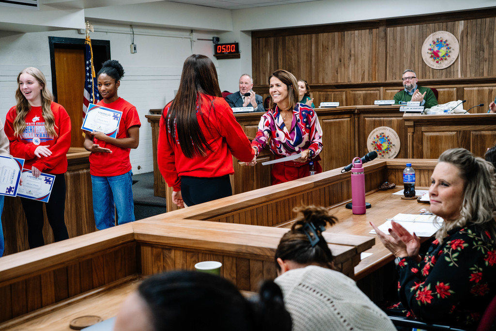HHHS volleyball player walking up to get her certificate at the kcs board of education meeting.