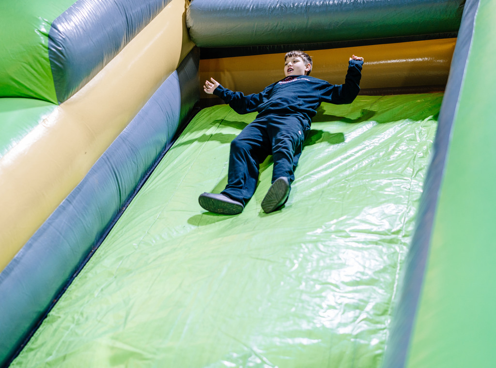 A student sliding down the top of the giant inflatable slide.