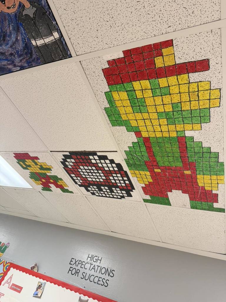 One large Mario character and a small Mario character, and a level up mushroom from the Nintendo Video Game Series Mario, have been painted on stretch of ceiling tiles at West Side Middle School by art students.