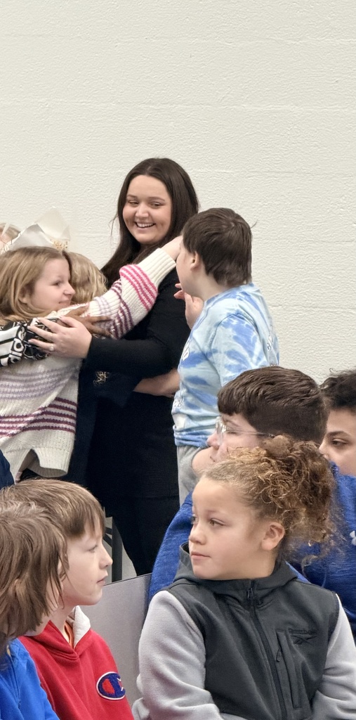 three students are hugging Taylor. 