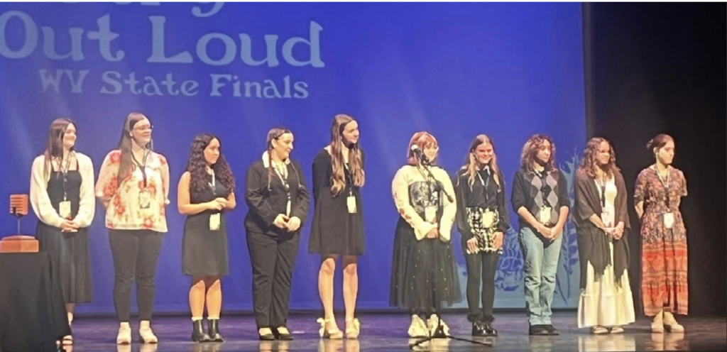 The top 10 students at the 2026 WV Poetry out Loud Competition standing on stage.  Behind them is a large screen that says Poetry Out Loud WV State Finals.