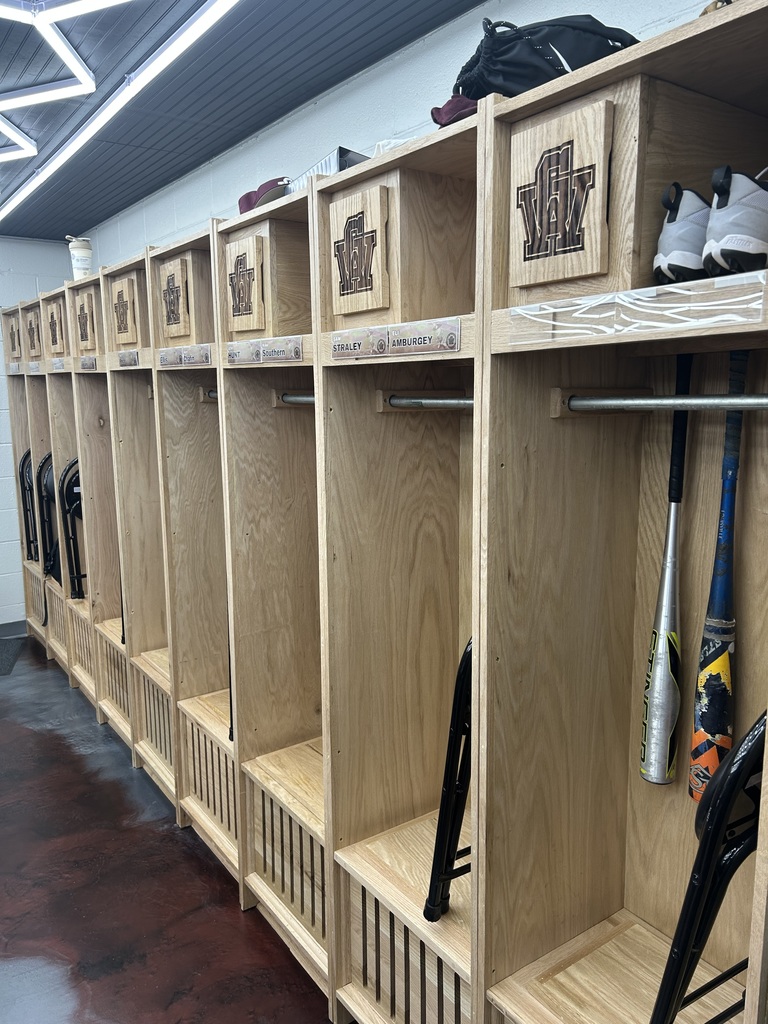A close up shot of the lockers in the GWHS baseball locker room. This picture is focused on a small storage area in the upper left hand corner of each locker. The door covering the storage area has GW letters engrained on them.
