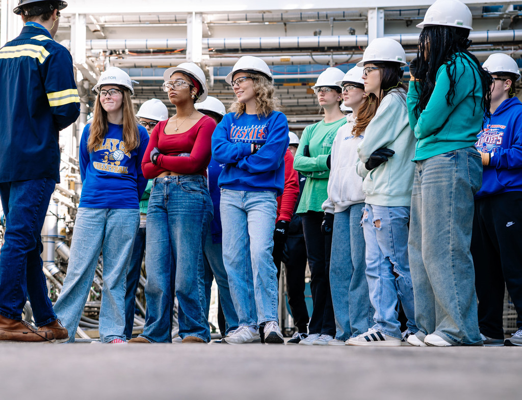 Students on a tour at the DOW Plant in South Charleston. Students are wearing hard hats, safety glasses, and safety gloves while are listening to a DOW employee talk