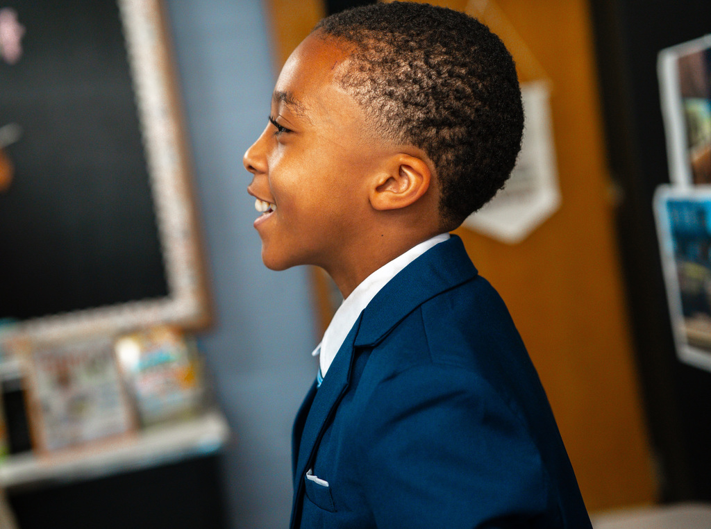 A student, smiling, dressed as Martin Luther King Jr. 