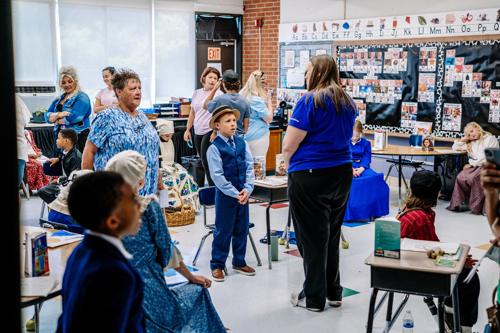 A classroom filled with students and visitors during the wax museum.