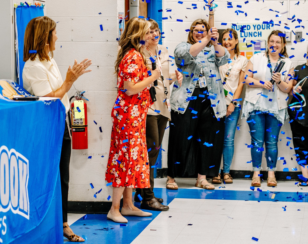 KCS Counselor of the Year, Emily Patterson, is smiling as confetti rains down as she is announced as the KCS counselor of the year. People are applauding in the background. 