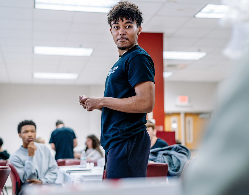 An SCHS student is holding Monopoly money with a smirk on his face as he tries to decide if he is going to accept an offer from the model bridge supply store. 