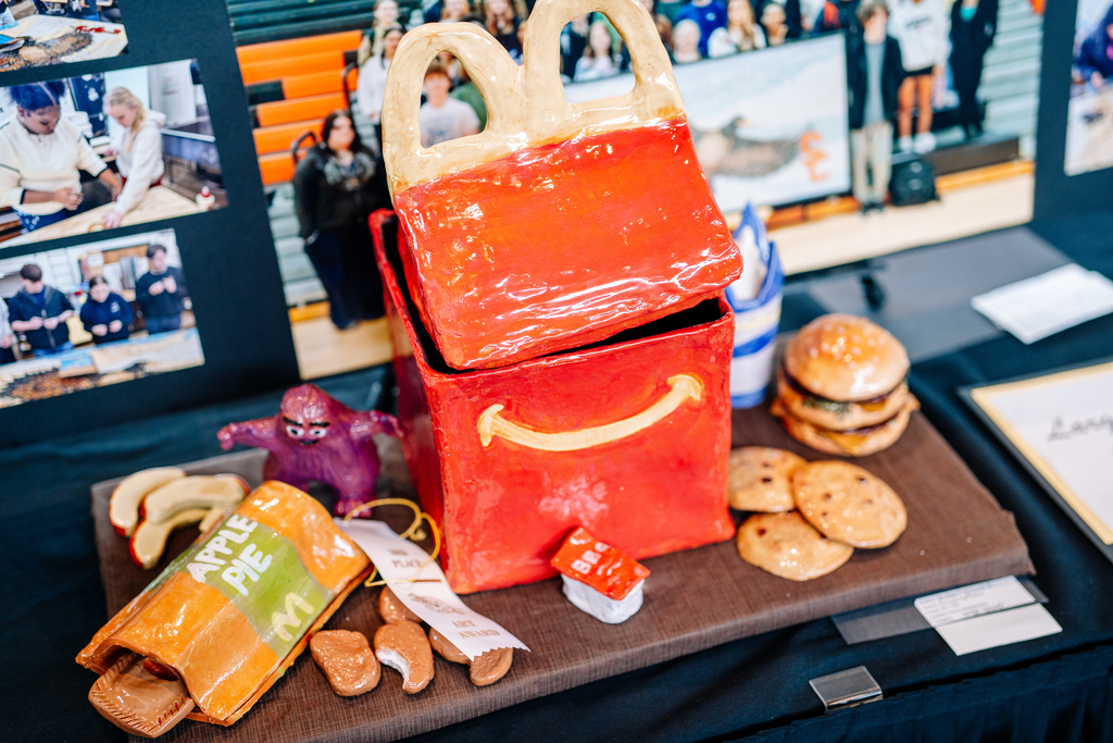 Pottery made to look like a McDonalds happy meal box, and pottery pieces that look like McDonalds hamburger, cookies, bbq sauce, apple pie, chicken nuggets, apples, and the hamburgler.