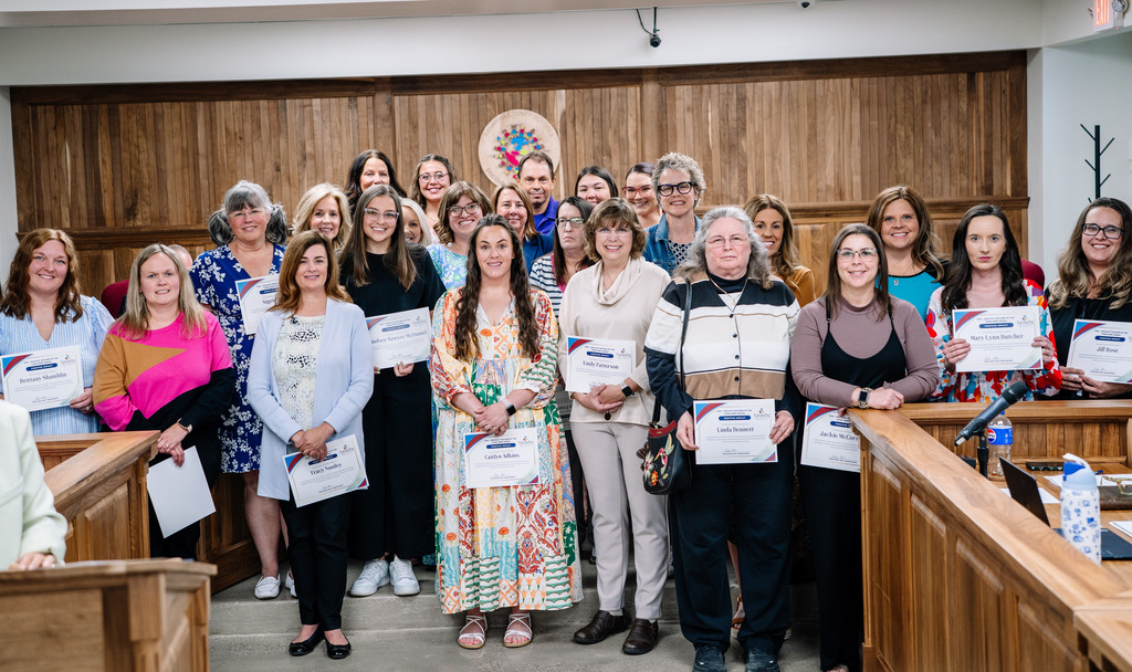 A group picture of elementary teachers who were honored for the third nine weeks. They are standing in the front of the kcs board room.