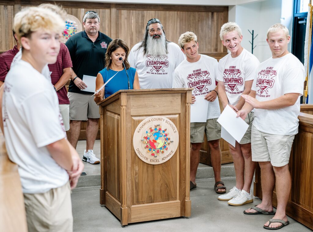 GWHS baseball players smiling was they watch their teammate called up to the podium to receive a certificate.