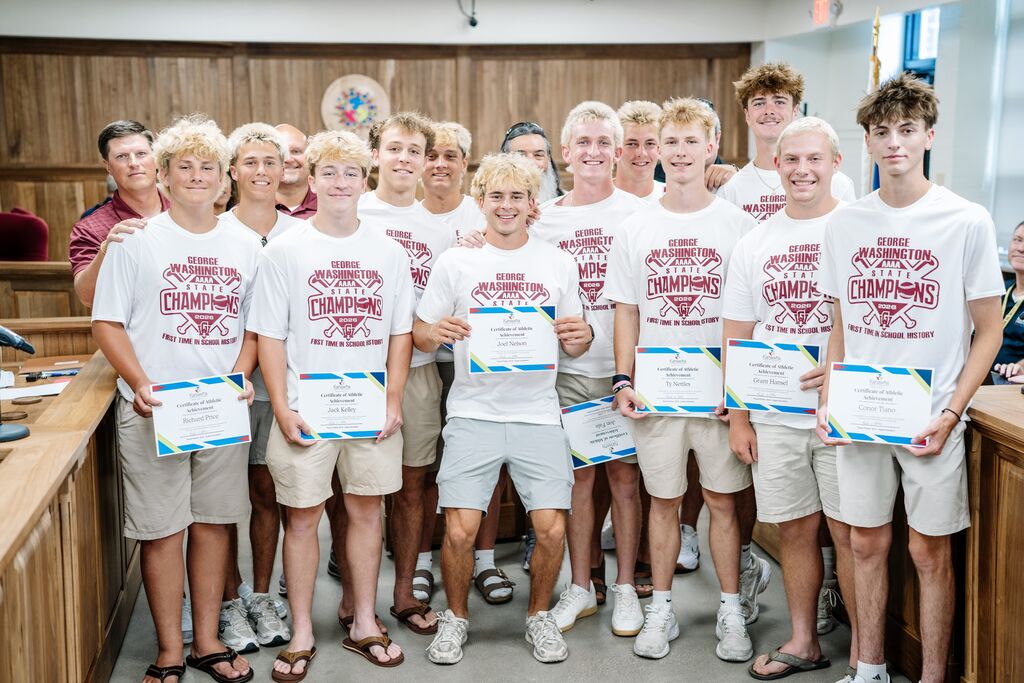 George Washington High School baseball team holding certificates and posing for a picture in the KCSBOE meeting room.