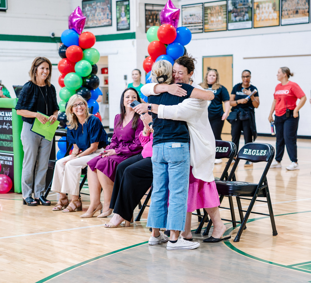 Shandon Tweedy giving a hug to KCS assistant superintendent Megan McCorkle in the school's gym.