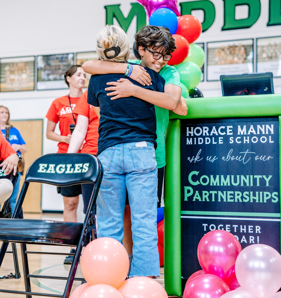 Shandon Tweedy hugging a student after he gave a speech about her in the school's gym.