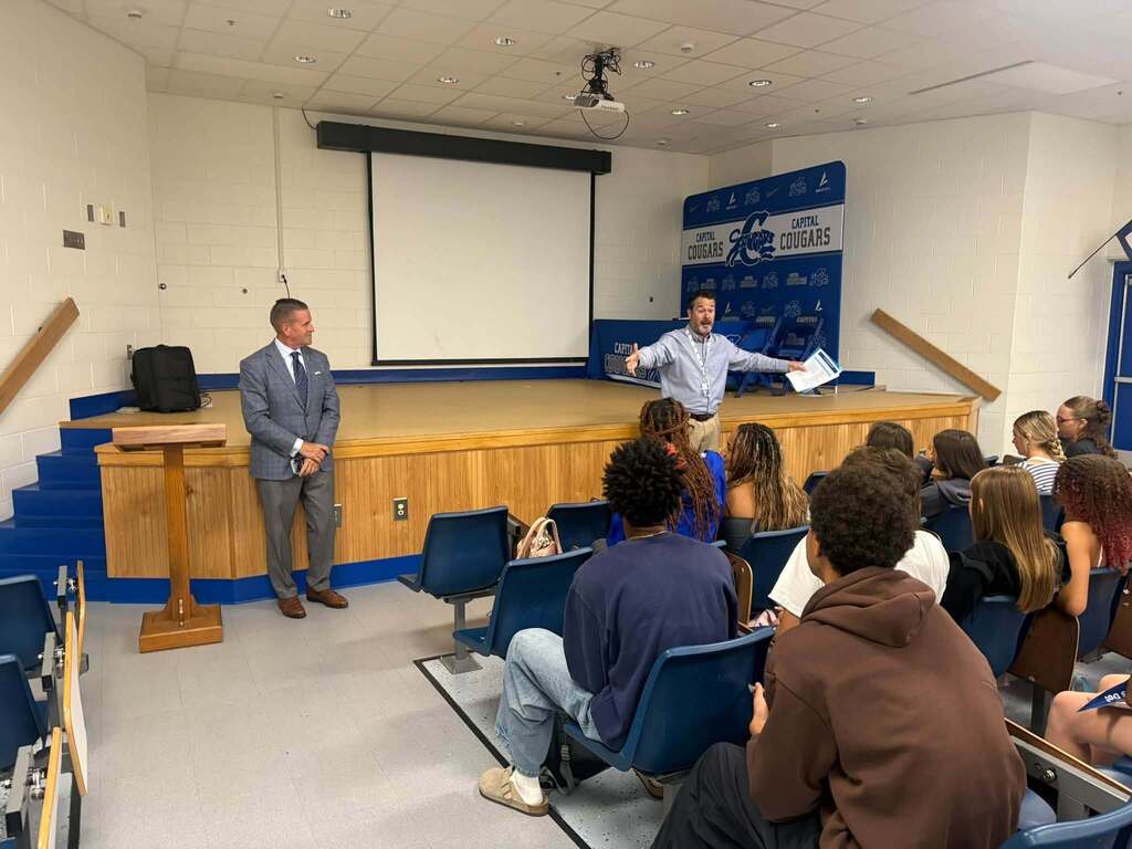 WVU President Michael Benson and KCS Lead Counselor Jon Duffy talking to Capital High School students in the school's reserve auditorium.