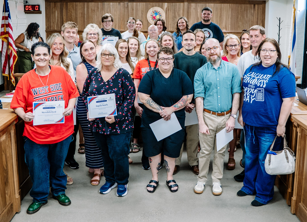 Middle school teachers standing in the KCSBOE Board room, posing for a picture.