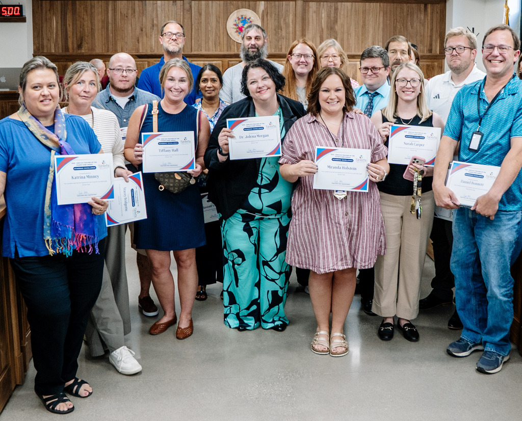 High school teachers standing in the KCSBOE Board room, posing for a picture.