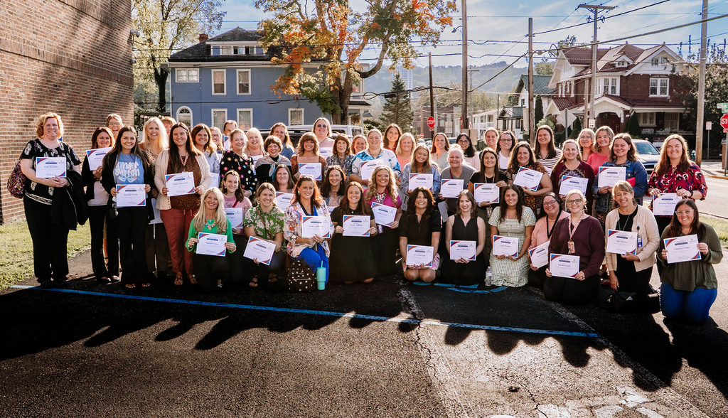 A large group of teachers posing for a group photo holding certificates that recognize them as the 2025-2026 Teachers of the 4th Nine Weeks for the 2025-2026 school year. 