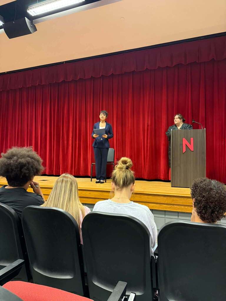 Students in the Nitro High School Auditorium, some in the audience seats and some on stage, doing a mock trial.