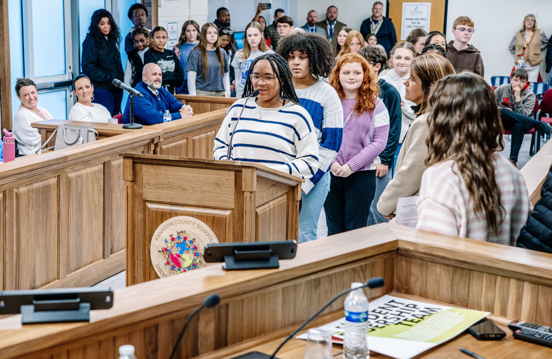 kcs student leadership team members introducing themselves at the podium in the KCS board room.