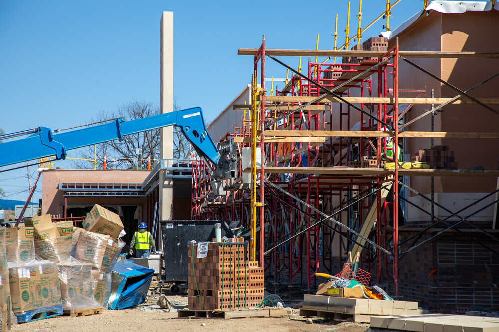 A construction site with scaffolding and a crane at the future King Empowerment Center