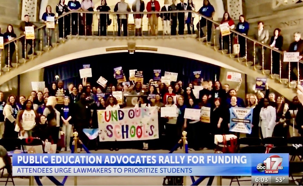 Public education advocates gather in the rotunda of the State Capitol.