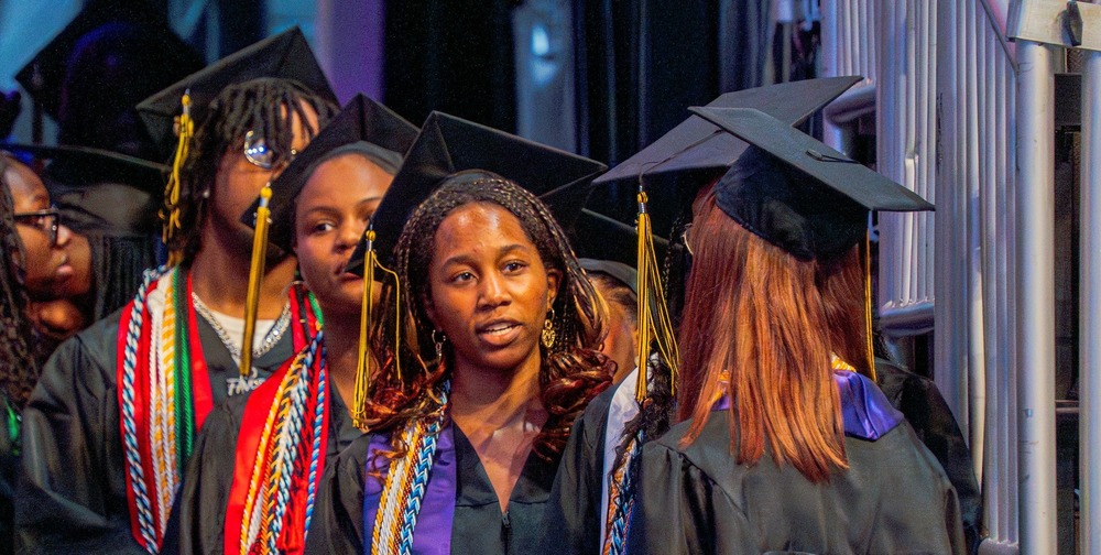 Students in graduation caps and gowns at a ceremony