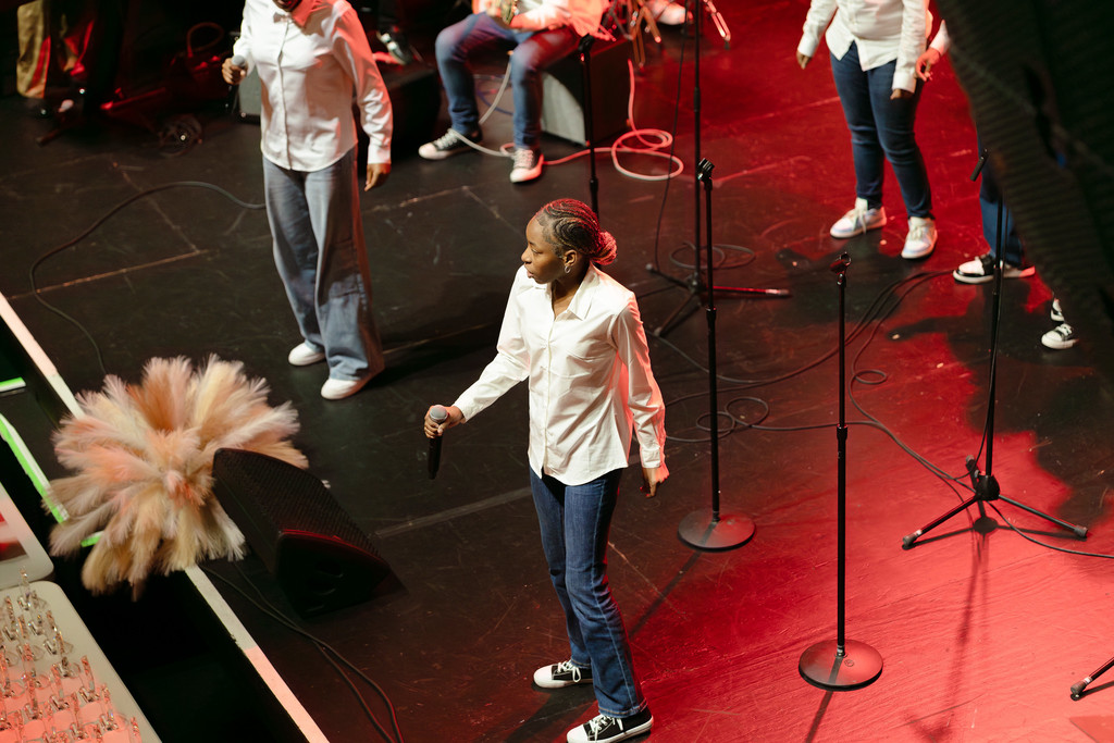 A student stands on a stage with a microphone for a performance