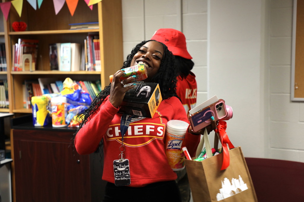 A teacher carrying a handful of free items for Teacher Appreciation Week