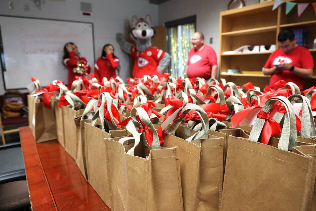 Bags full of goodies in the foreground for teacher appreciation week with Chiefs cheerleaders and KC Wolf in the background