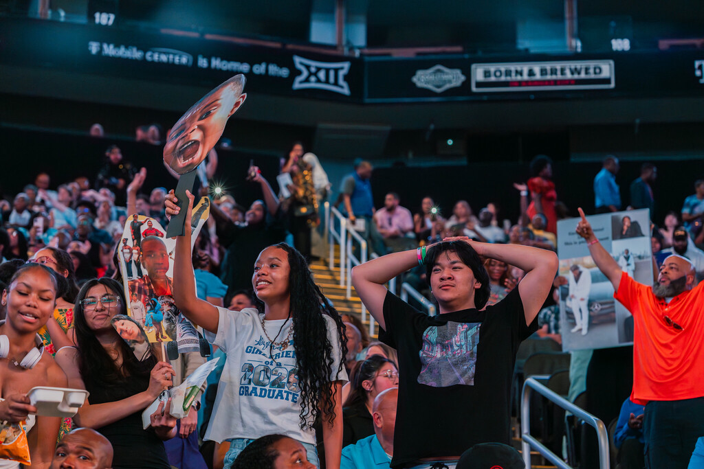 A crowd cheers on their students graduating