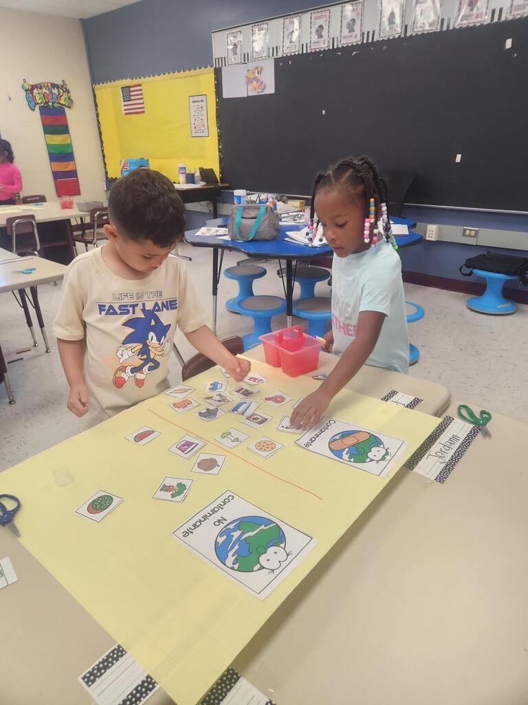 first grade students practice sorting recyclables with a classroom activity