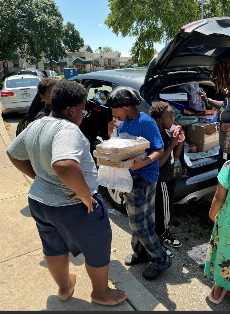 KCPS Family & Community Engagement Liaisons out in the community during summer break, interacting with family and students. The team is handing out pantry staples and ice cream to support and connect with the community.