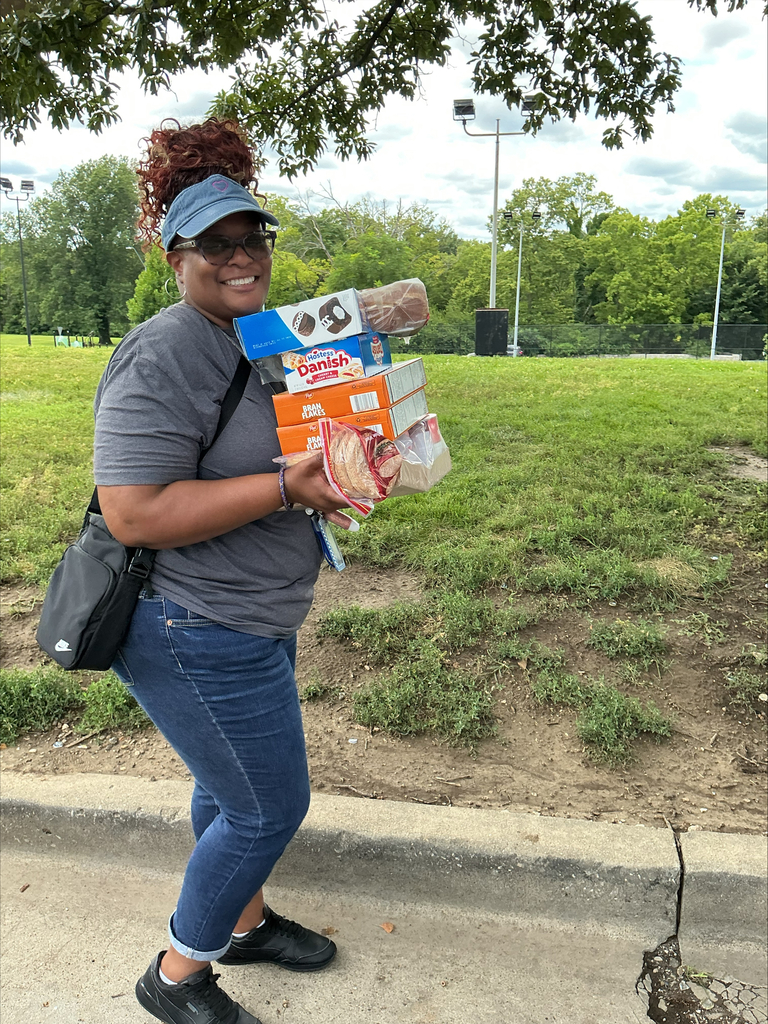 KCPS Family & Community Engagement Liaisons out in the community during summer break, interacting with family and students. The team is handing out pantry staples and ice cream to support and connect with the community.