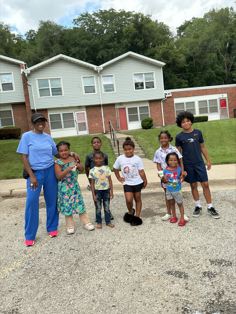 Garcia Family Liaison smiling alongside a few Garcia elementary students out in the community during a summer neighborhood visit,