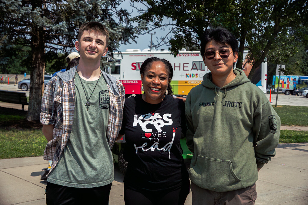 Two teenaged boys stand on either side of a woman, KCPS Superintendent dr. jennifer collier.