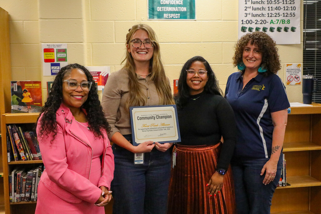 a group of four adult women stand smiling at the camera as the recipient of a superintendent award holds their certificate