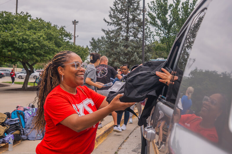 KCPS Superintendent Dr. Collier smiles as she hands a parent a free backpack through their car window