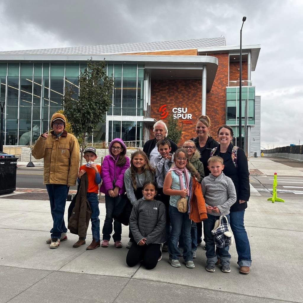 students and teachers pose on the sidewalk