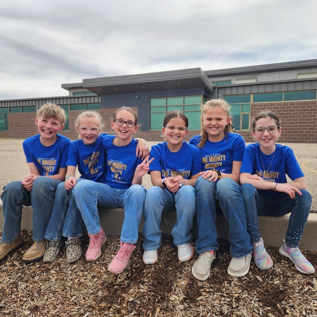 students pose in matching team shirts