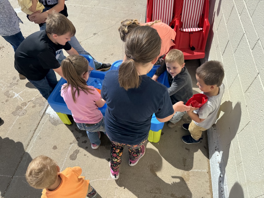 students gather around a water table at recess
