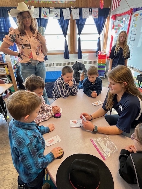 Teacher and K-2nd grade students learn as the FFA members teach them about animals.
