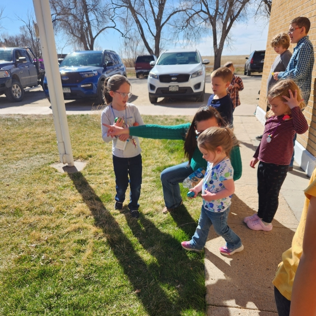 students gather for an egg race on the front lawn of the school